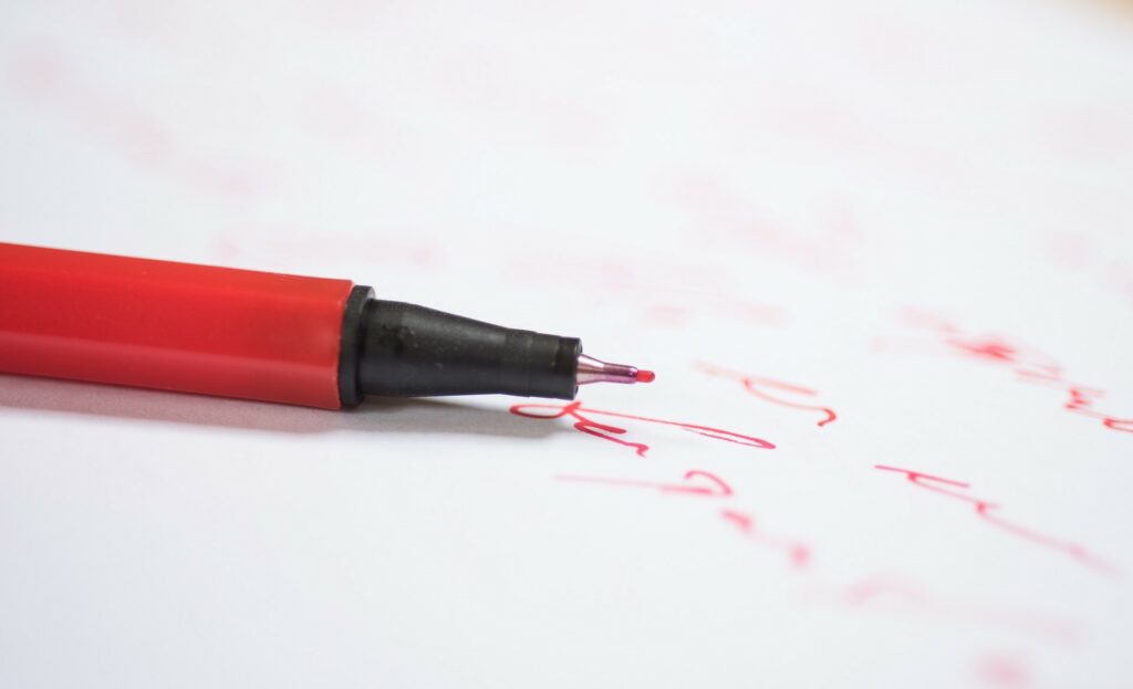 Rode pen als weergave voor het corrigeren of redigeren van een tekst
